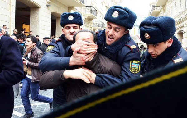 Three policemen man-handle one political activist during a protest in Baku Azerbaijan