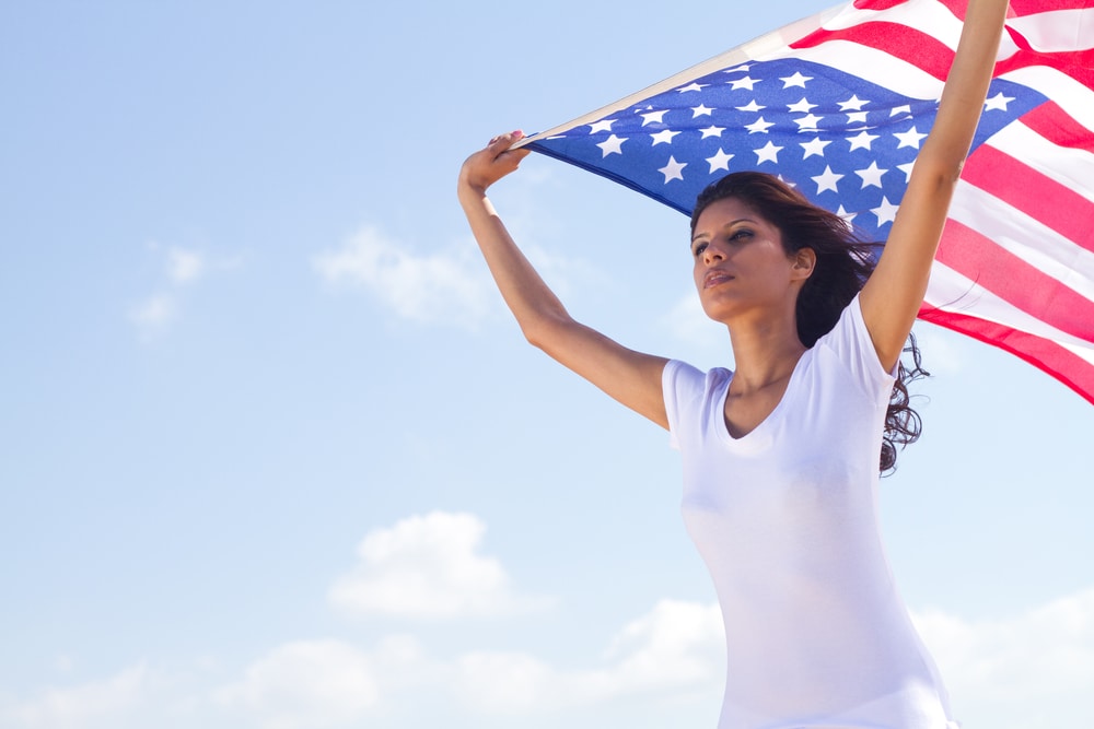 best ways to bring spouse to US wife holding USA flag in her hands